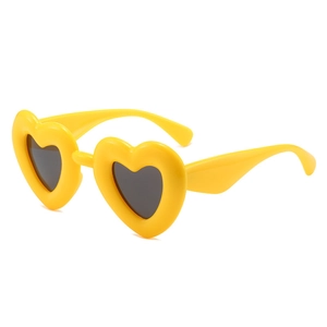 Fashionable bright yellow heart-shaped sunglasses with thick frames and black lenses
