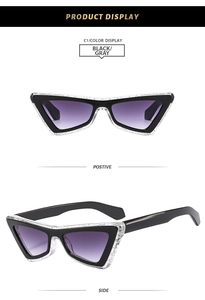 Detail view of cat eye sunglasses with black and glitter frames and purple gradient lenses