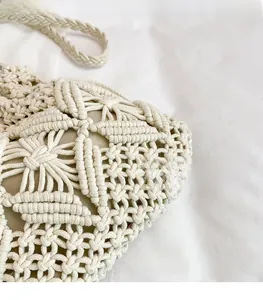 Macro detail of beige macrame bucket bag showing hollow geometric crochet patterns