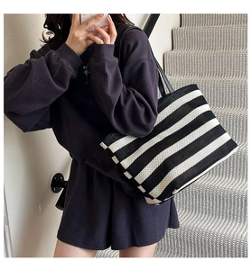Minimalist black and white striped tote bag shown in a casual daily outfit context