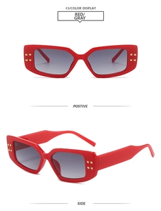 Macro detail of red rectangular sunglasses with gold rivets and gradient lenses
