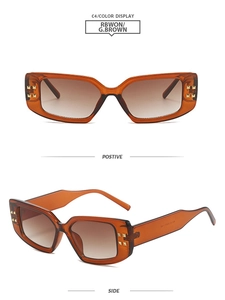 Detail of tortoise shell square sunglasses with gold rivets and brown gradient lenses