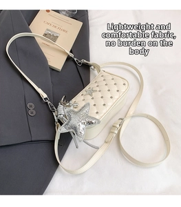 Close-up of cream quilted crossbody bag featuring silver stars and metallic rivets