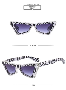 Close-up of cat-eye sunglasses with zebra stripe frames and purple gradient lenses