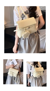 Close-up of cream PU leather bag texture with heart charm and versatile strap design