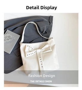 Nahaufnahme der weißen Oversize-Tasche mit großer Schleife und silbernen Nietendetails