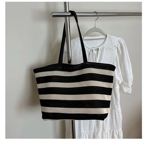 Close-up of black and white striped tote bag showing fine woven texture and sturdy strap