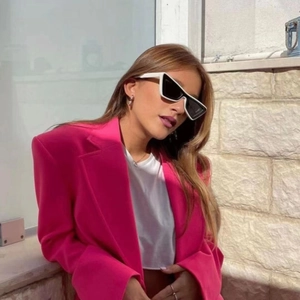 Fashionable cat-eye sunglasses paired with a hot pink oversized blazer and white accessories