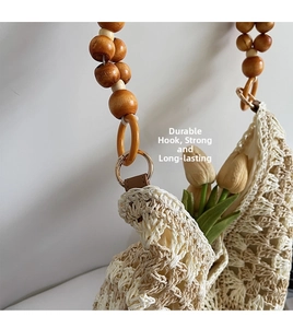 Detail of woven beach tote showing wood bead strap and gold metal ring connection