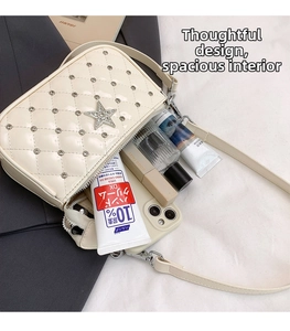 Detail view of cream quilted crossbody bag interior holding makeup and phone