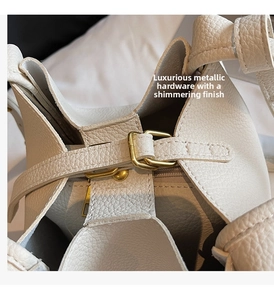 Detail of premium beige pebbled leather texture with elegant golden metal clasp hardware