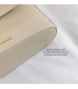 Close-up of beige canvas and faux leather texture with elegant gold brand logo