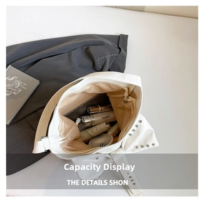 Top view of white PU tote bag interior with silver studs showing spacious storage