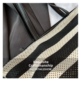 Close-up of black and white striped woven mesh tote bag with premium leather handle