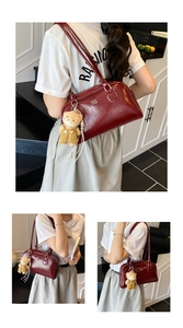 Détail du sac bandoulière en cuir bordeaux avec lettrage blanc et breloque ours