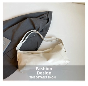 Detail view of cream white faux leather shoulder bag with adjustable wide strap and texture