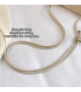 Detail of smooth beige shoulder strap with metal buckles and stylish knot elements