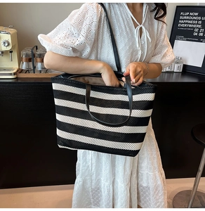 Detail of the black and white striped woven tote bag with premium leather shoulder straps