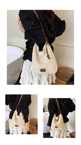 Detail of hollow woven shoulder bag with brown leather strap and brand logo patch