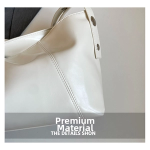 Detail view of cream shoulder bag featuring premium faux leather and silver metal buckles