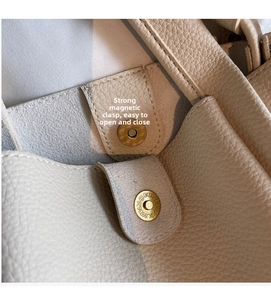 Close-up of a strong magnetic closure on a beige lychee pattern leather bucket bag