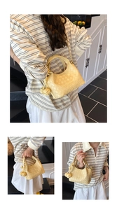 Détail du sac seau tissé crème avec chaîne dorée et pendentif en cuir noué élégant