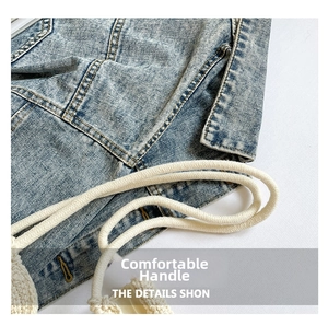 Detailed macro view of denim fabric texture and braided cotton rope handle with stitching
