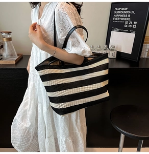 Détail du grand sac cabas tissé à rayures noires et blanches avec anses en cuir