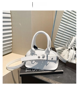 Détail du sac à main blanc en cuir grainé avec boucle de ceinture argentée et poignée