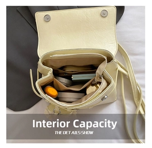 Interior view of cream leather flap backpack showing multi-compartment storage space
