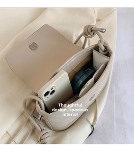 Interior detail of a beige crossbody bag showing ample space for a phone and cosmetics
