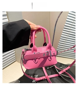 Détail du sac à main rose motif litchi avec lanières décoratives et rivets métalliques