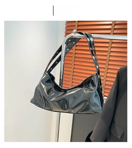 Détail du sac à main en similicuir noir brillant avec clous argentés sur la bandoulière