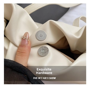 Close-up of the silver magnetic closure on a beige PU leather shoulder bucket bag