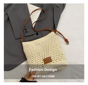 Detail of beige crochet tote with brown leather strap and decorative wood bead