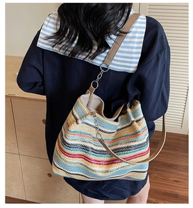 Detail of colorful striped woven tote bag with leather and metal chain shoulder strap