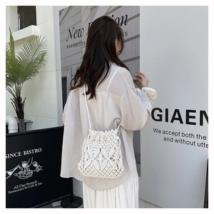 Detail of white hollow crochet bucket bag with drawstring closure for beach vacation style