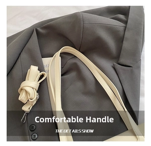 Detail showing the comfortable wide handle and adjustable metal buckle shoulder strap