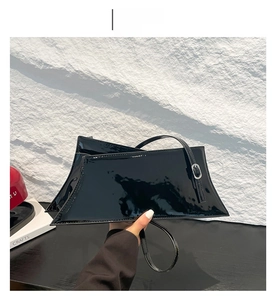 Détail du sac à épaule en cuir verni noir avec fini brillant et boucle argentée