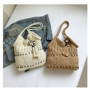 Detailed view of handmade woven tote bags with fringe and wood bead accents