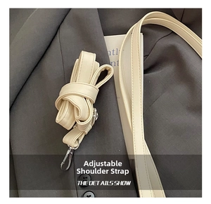 Detail of adjustable beige PU leather shoulder strap with silver metal lobster clasps