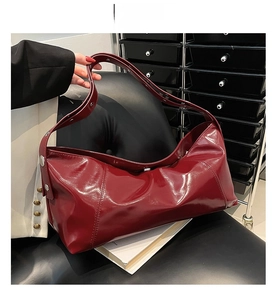 Vue détaillée du sac croissant en cuir ciré rouge avec bandoulière large réglable