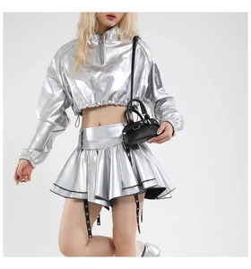 Close-up of a trendy black mini shell handbag paired with a metallic silver two-piece outfit