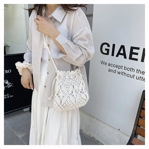 Detail view of the white handmade crochet bucket bag with intricate leaf pattern texture