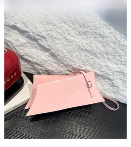 Détail d'un sac à main géométrique en cuir verni rose avec boucles argentées