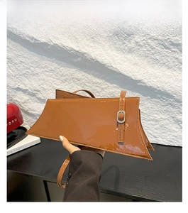 Détail du sac à bandoulière en cuir verni marron brillant avec boucle argentée et coutures
