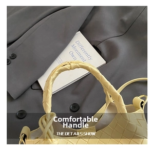 Gros plan sur la poignée nouée épaisse et la texture en cuir tressé du sac seau jaune