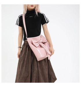 Detail of pink bow tote bag featuring glossy patent leather and metallic rivets