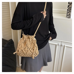 Macro shot of beige Macramé woven bucket bag with drawstring and wood beads