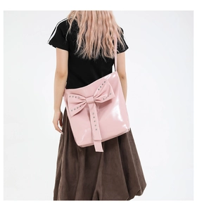 Detail der rosa Lackledertasche mit silbernen Nieten auf einer großen 3D-Schleife